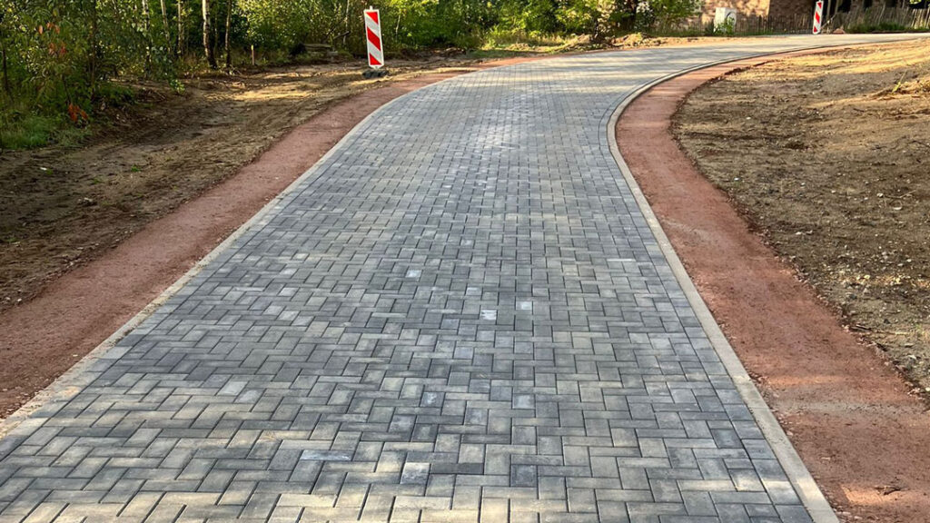 Präzise Pflasterarbeiten für eine geschwungene Einfahrt im Wendland – Fachgerechte Ausführung durch den Meisterbetrieb Bleck GmbH.